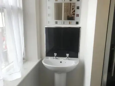 a white sink in a white bathroom with a mirror at Boomerang Blackpool in Blackpool