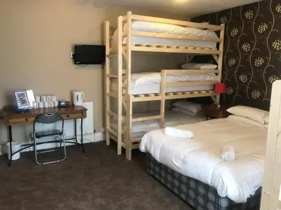 a room with two bunk beds and a desk at Boomerang Blackpool in Blackpool