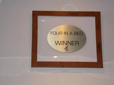 a wooden frame with a sign that reads four in a bed winner at The Trafford Hotel in Blackpool