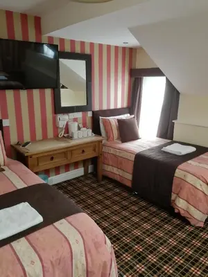 a hotel room with two beds and a mirror at The Trafford Hotel in Blackpool
