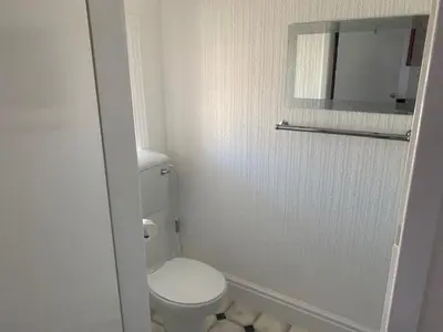 a white bathroom with a toilet and a mirror at The Mornington Hotel in Blackpool