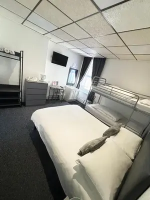 a bedroom with a large bed and a tv at The Mornington Hotel in Blackpool