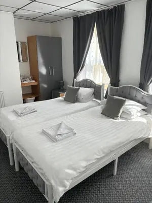 two twin beds in a room with a window at The Mornington Hotel in Blackpool