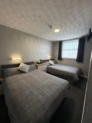 a room with two beds and a window in it at Clifton Private Hotel in Blackpool