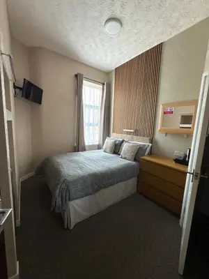 a hotel room with a bed and a window at Clifton Private Hotel in Blackpool