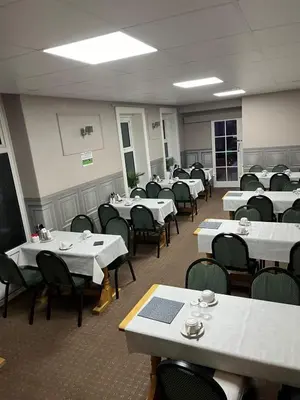 a dining room with white tables and chairs at Clifton Private Hotel in Blackpool