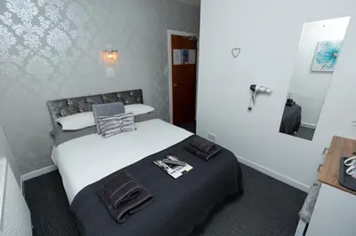 a bedroom with a bed and a mirror at The Carlton in Blackpool