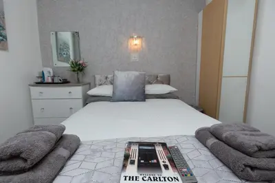 a bedroom with a bed with a book on it at The Carlton in Blackpool