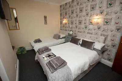 a bedroom with two beds and a tv at The Carlton in Blackpool