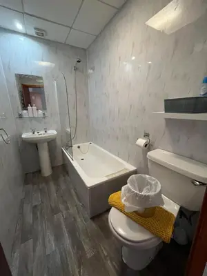 a bathroom with a toilet and a tub and a sink at The Carlton in Blackpool