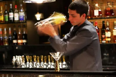 a man standing behind a bar preparing a drink at The Vincent Hotel in Southport