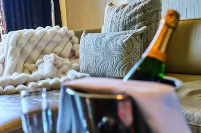 a bottle of wine sitting on a table next to a couch at The Vincent Hotel in Southport