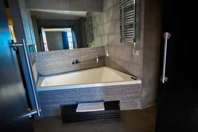 a bath tub in a bathroom with a mirror at The Vincent Hotel in Southport