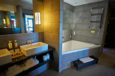 a bathroom with a large tub and a sink at The Vincent Hotel in Southport