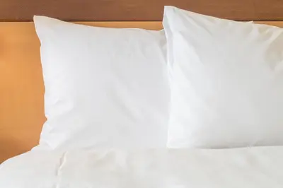 a stack of white pillows on a bed at Staybridge Suites Liverpool by IHG in Liverpool