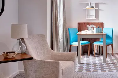 a living room with a chair and a table at Staybridge Suites Liverpool by IHG in Liverpool