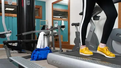a woman running on a treadmill in a gym at Staybridge Suites Liverpool by IHG in Liverpool