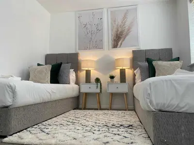 a bedroom with two beds and a couch at Sutton Heath Lodge in Saint Helens
