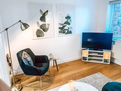 a living room with a chair and a television at Sutton Heath Lodge in Saint Helens