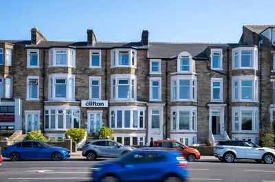 a building with cars parked in front of it at The Clifton Seafront Hotel in Morecambe