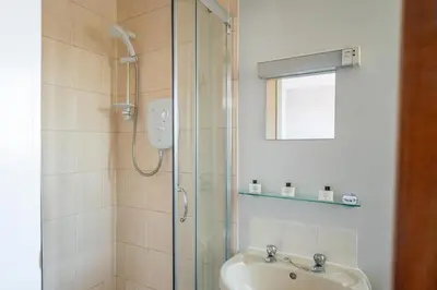 a bathroom with a shower and a sink at The Clifton Seafront Hotel in Morecambe