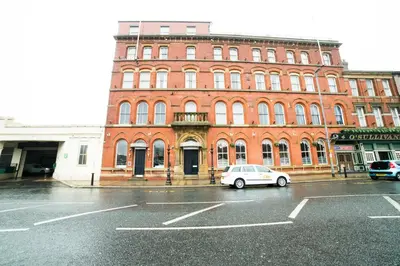 a white car parked in front of a brick building at OYO Imperial Hotel in Barrow in Furness