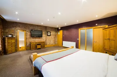 a bedroom with a large bed and a television at OYO Imperial Hotel in Barrow in Furness