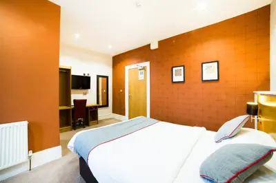 a hotel room with a bed and a desk at OYO Imperial Hotel in Barrow in Furness