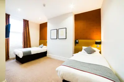 a hotel room with two beds and a window at OYO Imperial Hotel in Barrow in Furness