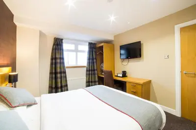 a hotel room with a bed and a television at OYO Imperial Hotel in Barrow in Furness