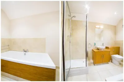 a bathroom with a tub and a shower and a sink at OYO Imperial Hotel in Barrow in Furness