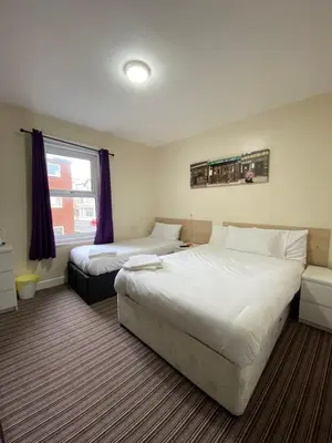 a hotel room with two beds and a window at South Beach Hotel in Blackpool