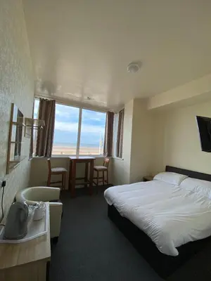 a hotel room with a bed and a bathroom with a window at South Beach Hotel in Blackpool