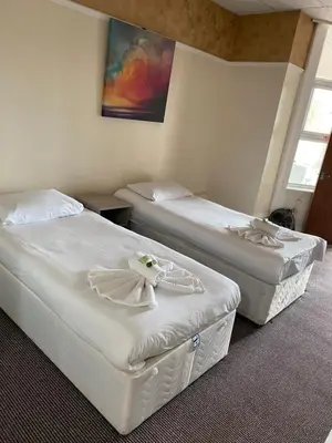 two beds in a hotel room with white sheets at South Beach Hotel in Blackpool
