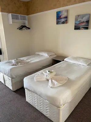 a hotel room with two beds with towels on them at South Beach Hotel in Blackpool