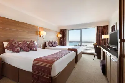 a hotel room with two beds and a television at Waterfront Southport Hotel in Southport