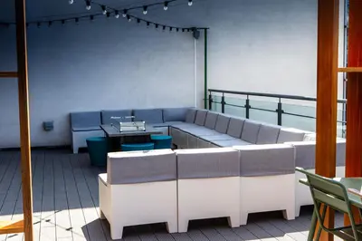 a room with couches and tables on a balcony at Waterfront Southport Hotel in Southport