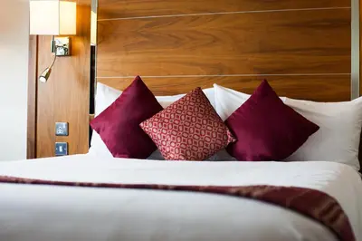 a bedroom with a bed with purple and white pillows at Waterfront Southport Hotel in Southport