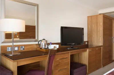 a hotel room with a desk with a flat screen tv at Waterfront Southport Hotel in Southport