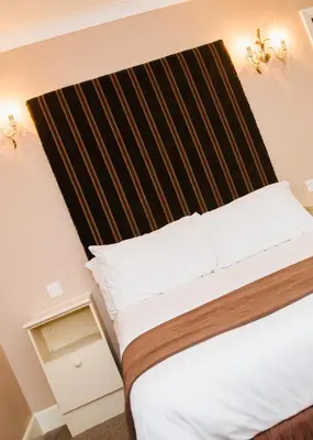 a bedroom with a bed with a wooden headboard at Park House Hotel in Blackpool