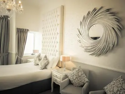a bedroom with a bed and a mirror and a chair at Park House Hotel in Blackpool
