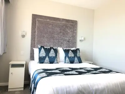 a bedroom with a large bed with blue and white pillows at Park House Hotel in Blackpool