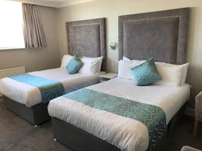 a hotel room with two beds with blue pillows at Park House Hotel in Blackpool