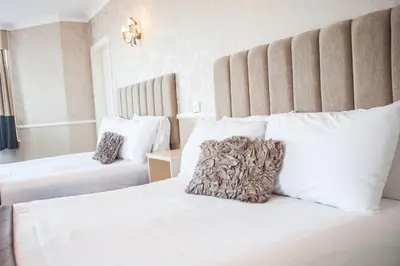 a bedroom with a white bed with a large headboard at Park House Hotel in Blackpool