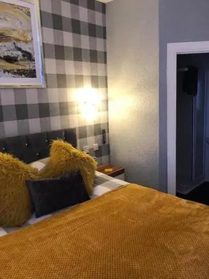 a bedroom with a bed with a yellow blanket on it at Springfield Hotel in Blackpool