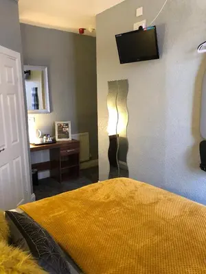 a bedroom with a bed and a desk and a television at Springfield Hotel in Blackpool