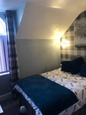 a bedroom with a bed with a blue blanket on it at Springfield Hotel in Blackpool