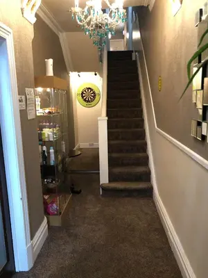 a hallway with a staircase with a chandelier at Springfield Hotel in Blackpool