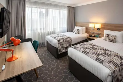 a hotel room with two beds and a table at Holiday Inn Preston by IHG in Preston
