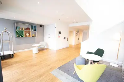 a living room with a yellow chair and a table at Holiday Inn Preston by IHG in Preston